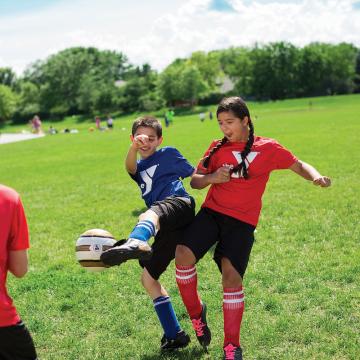 Kids playing in youth soccer league game Kids playing in youth soccer league game