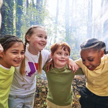 Group of kids outdoors in a circle smiling Group of kids outdoors in a circle smiling