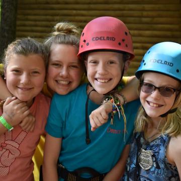 Kids posing for a picture together before climbing a ropes course Kids posing for a picture together before climbing a ropes course