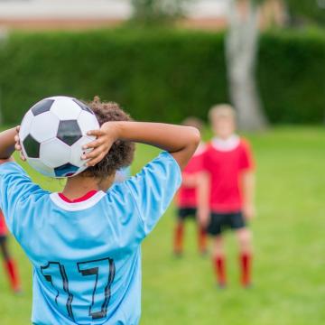 Child getting ready to throw soccer ball into play Child getting ready to throw soccer ball into play