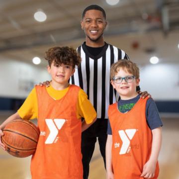 Smiling referee standing with two young basketball players Smiling referee standing with two young basketball players