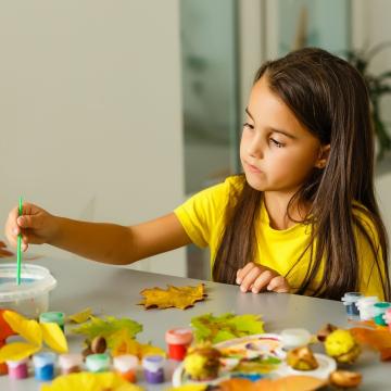 Young girl sitting at table painting Young girl sitting at table painting