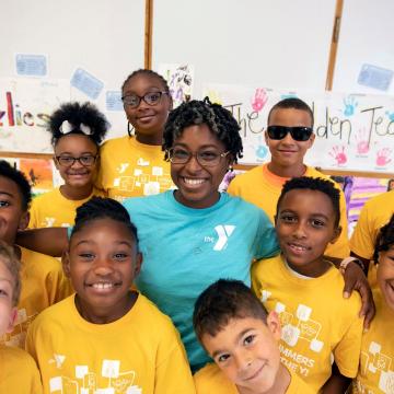 Child care staff member standing with a group of children Child care staff member standing with a group of children