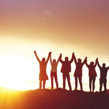 Silhouette of group of teens standing together holding hands Silhouette of group of teens standing together holding hands