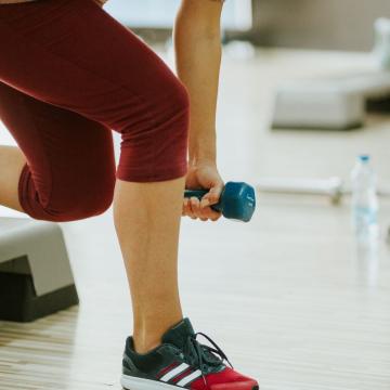 Person lifting a handweight on a workout step Person lifting a handweight on a workout step