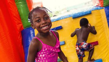 Girl and boy playing in a bounce house